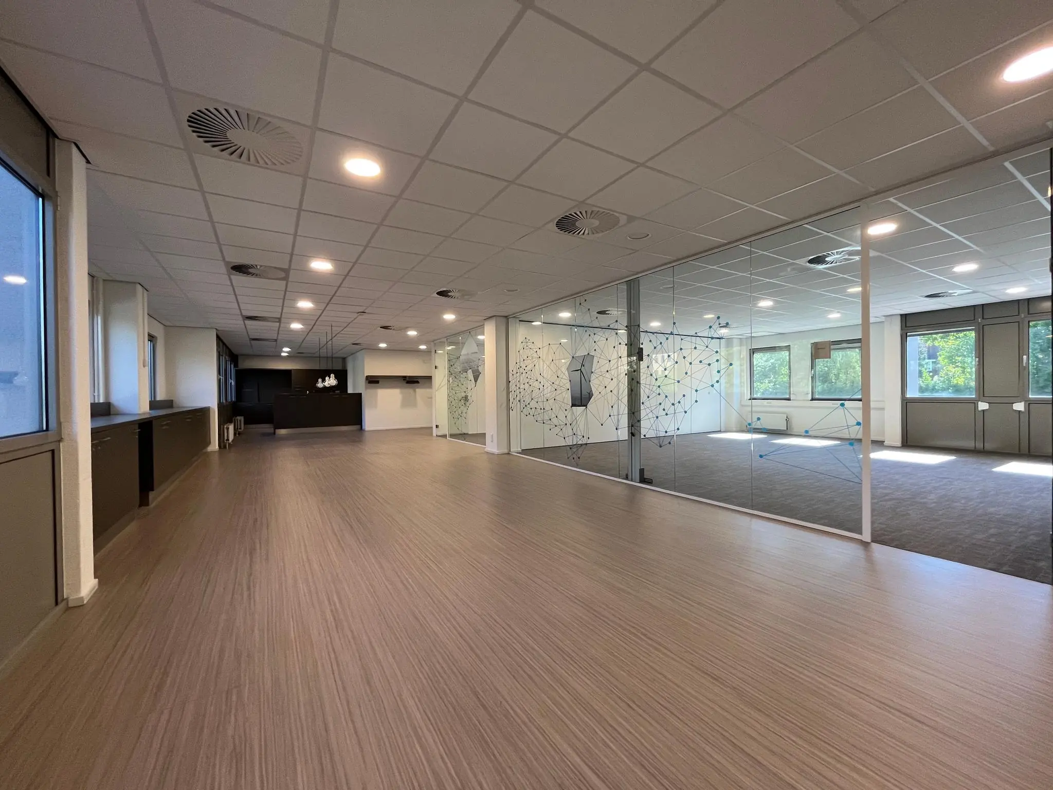 Moderne, open kantoorruimte aan de Barchman Wuytierslaan met glazen wanden en strakke afwerking.